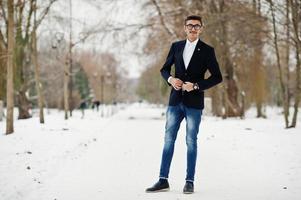 stijlvolle Indiase student man in pak en bril poseerde op winterdag buiten. foto