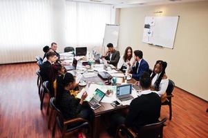 multiraciale jonge creatieve mensen in moderne kantoren. groep jonge zakenmensen werken samen met laptop, tablet. succesvol freelancers-team in coworking. foto