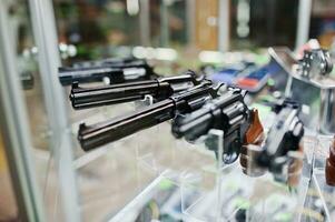 verschillende geweren en revolvers op planken slaan wapens op in het winkelcentrum. foto