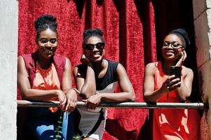 drie stijlvolle Afro-Amerikaanse dames poseerden op zonnige zomerdag buiten. foto