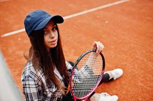 jonge sportieve meisjesspeler met tennisracket op tennisbaan. foto