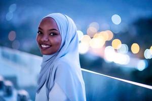 Afrikaanse moderne moslimvrouw in de nacht op het balkon foto