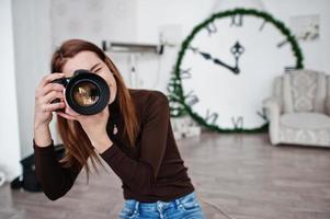 jong meisje fotograaf schieten op studio. professionele fotograaf op het werk. foto