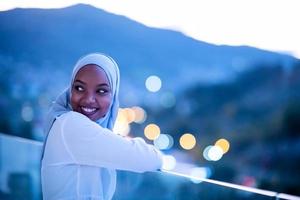 Afrikaanse moderne moslimvrouw in de nacht op het balkon foto