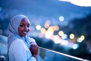 Afrikaanse moderne moslimvrouw in de nacht op het balkon foto