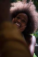 close-up portret van een mooie jonge Afro-Amerikaanse vrouw die lacht en omhoog kijkt foto