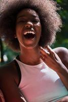 close-up portret van een mooie jonge Afro-Amerikaanse vrouw die lacht en omhoog kijkt foto