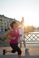 jong stel joggen over de brug in de stad foto