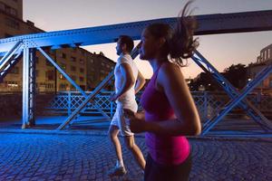 paar joggen over de brug in de stad foto