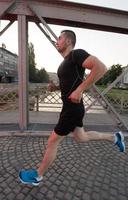 man joggen over de brug op zonnige ochtend foto