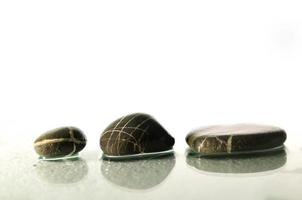 geïsoleerde natte zen-stenen met opspattende waterdruppels foto