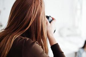 close-up achterkant van jonge meisje fotograaf schieten op studio. professionele fotograaf op het werk. foto