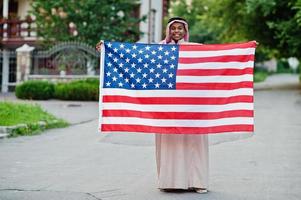 Arabische man uit het Midden-Oosten poseerde op straat met de vlag van de VS. amerika en arabische landen concept. foto