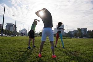 multi-etnische groep mensen die zich uitstrekt in stadspark foto