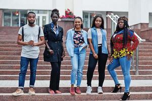 groep van vijf afrikaanse studenten die samen tijd doorbrengen op de campus op de universiteitswerf. zwarte afro-vrienden studeren. onderwijs thema. foto