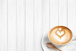 een kopje koffie latte met lepel op hout blackground foto