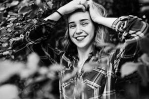 close-up portret van een lachend blond meisje in tartan shirt op het platteland. foto