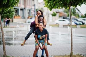 drie Afro-Amerikaanse vrienden die samen plezier hebben. op schouder springen. foto