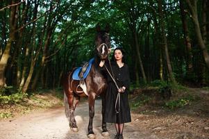 mystieke meisjeskleding in zwart met paard in hout. foto