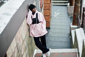 stijlvolle stedelijke stijl Afro-Amerikaanse man in roze hoodie gesteld op winterdag. foto