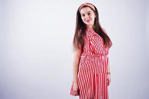 portret van een prachtig jong meisje in een rood gestreepte jurk in de studio. foto