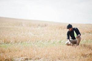 Zuid-Aziatische landbouwkundige boer inspecteert tarweveld boerderij. landbouwproductieconcept. foto