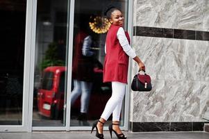 Afro-Amerikaanse meisje met handtas poseerde buiten van steets city. foto