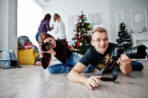 het team van twee fotografen ligt op de grond en fotografeert in de studio. foto