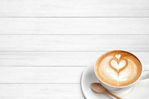 een kopje koffie latte met lepel op hout blackground foto