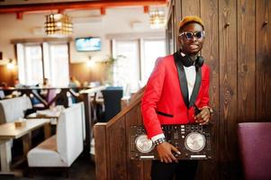 mode Afro-Amerikaanse man model dj op rood pak met dj-controller. foto