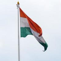 indiase vlag hoog op connaught plaats met trots in blauwe lucht, indiase vlag wapperen, indiase vlag op onafhankelijkheidsdag en republiek dag van india, tilt-up shot, wuivende indische vlag, har ghar tiranga foto