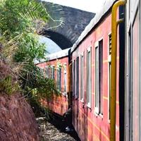 speelgoedtrein die zich op berghellingen beweegt, prachtig uitzicht, een zijberg, een zijvallei die zich op een spoorlijn naar de heuvel beweegt, tussen groen natuurlijk bos. speelgoedtrein van kalka naar shimla in india, indiase trein foto