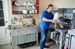 prothetist man die prothetisch been maakt terwijl hij in het laboratorium werkt. foto