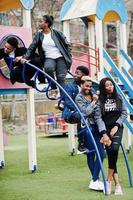 jonge millennials Afrikaanse vrienden op speelplaats, glijbaan en schommel. gelukkige zwarte mensen die samen plezier hebben. generatie z vriendschapsconcept. foto