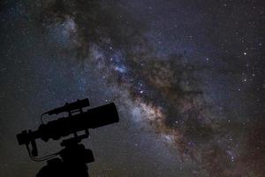 silhouet van telescoop kijken naar de Melkweg op de nachtelijke hemel foto