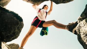 lage hoek close-up een jonge blanke sportieve vrouw alleen trein rotsklim buitenshuis in zonnig warm weer alleen. inspirerende actieve sterke vrouw sportactiviteiten buitenshuis foto