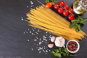 pasta en koken ingrediënten op zwarte leisteen achtergrond. foto