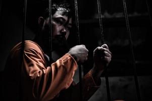 aziatische man wanhopig in de ijzeren gevangenis, gevangene concept, thailand mensen, hoop vrij te zijn, serieuze gevangenen opgesloten in de gevangenis foto