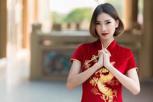 portret mooie aziatische vrouw in cheongsam-jurk, thailand-mensen, gelukkig chinees nieuwjaarsconcept, gelukkige aziatische dame in chinese klederdracht foto