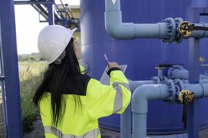 milieu-ingenieurs werken bij afvalwaterzuiveringsinstallaties, vrouwelijke loodgieter technicus werken bij watervoorziening foto