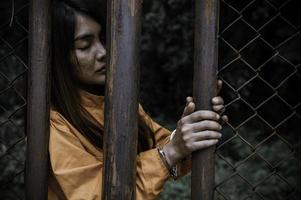 portret van vrouwen die wanhopig op zoek zijn naar de ijzeren gevangenis, het concept van de gevangene, de mensen van Thailand, hopen vrij te zijn, als de wet wordt overtreden, zou worden gearresteerd en gevangen gezet. foto