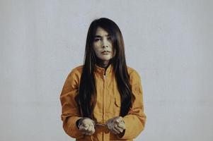 gevangene in oranje gewaad concept, portret van Aziatische vrouw in gevangenis uniformen op witte achtergrond, foto