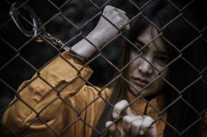 portret van vrouwen die wanhopig op zoek zijn naar de ijzeren gevangenis, het concept van de gevangene, de mensen van Thailand, hopen vrij te zijn, als de wet wordt overtreden, zou worden gearresteerd en gevangen gezet. foto
