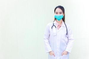Aziatische vrouwelijke arts draagt een medisch gezichtsmasker om het coronavirus te beschermen foto