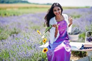 mooi indiaans meisje draagt saree india traditionele kleding in paars lavendelveld. foto