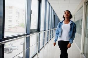 Afrikaanse vrouw in jeans jasje poseerde binnen. foto