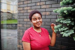 afrikaanse vrouw draagt een rood t-shirt dat buiten poseert. foto