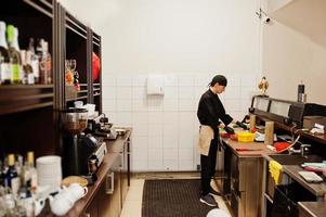 professionele chef-kok draagt in het zwart sushi en broodjes in een restaurantkeuken van japans traditioneel eten. foto