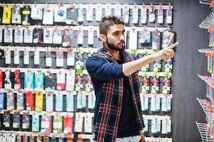 indiase man klant koper bij mobiele telefoon winkel kiest een hoesje voor zijn smartphone. Zuid-Aziatische volkeren en technologieën concept. gsm winkel. foto