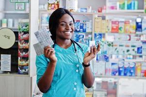 Afro-Amerikaanse apotheker werkzaam in drogisterij bij ziekenhuisapotheek. afrikaanse gezondheidszorg. foto